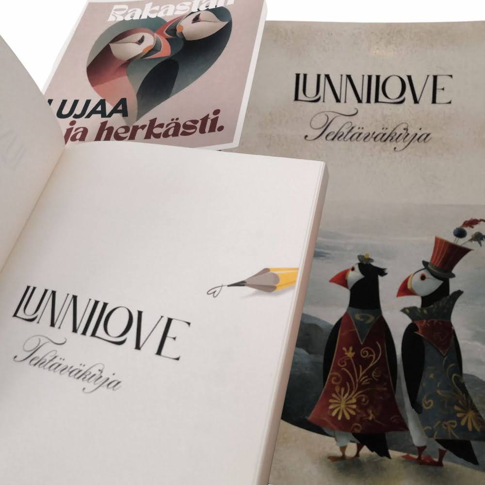 Lunnilove-tehtäväkirjan ensimmäinen lehti, jossa on lyijykynä, joka on piirtänyt sydämen ja otsikko Lunnilove Tehtäväkirja. Sen takana on lunnikortti "Rakastan lujaa ja herkästi" sekä tehtäväkirjan kansi, jossa on kaksi viittoihin pukeutunutta lunnia kävelemässä meren rannalla.